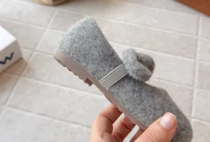 Detail view of gray fleece-lined furry girls' shoes with a soft non-slip rubber sole.