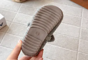 Detailed view of the anti-slip wavy rubber sole on a gray fuzzy toddler shoe in size 23