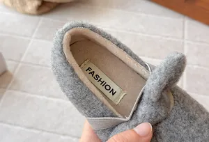 Close-up detail of grey furry princess shoes for girls with warm plush lining and fashion label