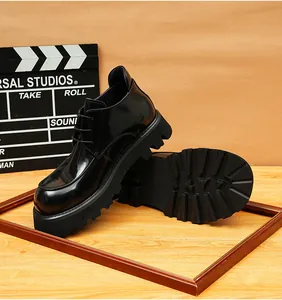 Glossy black men's leather boots with thick platform lug soles on a wooden display