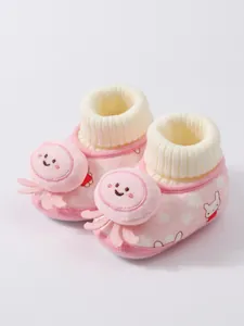 Close-up of pink baby winter booties with cute octopus decor and soft knit cuff