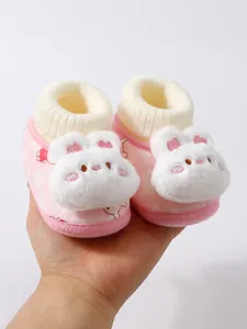 Close-up of soft pink baby shoes with plush white bunny face and knitted ankle cuffs