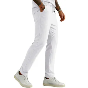 Macro view of white corduroy men's trousers featuring a drawstring waist and straight leg fit.