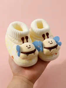 Detailed view of plush baby booties with cute bee design and soft knit cuffs
