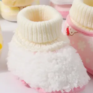 Detailed macro view of warm white fleece baby booties with a soft knitted pink cuff