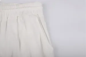 Detailed macro view of white corduroy men's casual trousers featuring elastic waistband