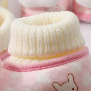 Close-up of soft ribbed knit cuff and pink plush fabric on warm baby winter booties.