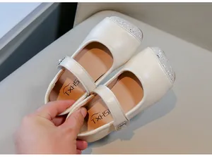 Detailansicht cremefarbener Mädchen-Mary-Janes mit silberner Glitzerspitze und Riemchen.