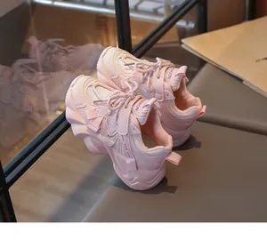 Close-up of stylish pink girls' mesh sneakers with chunky soles and lace-up design.
