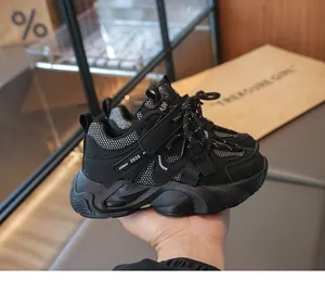 Close-up of black children's mesh running shoes with chunky soles and fashion accents.