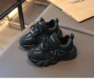 Macro view of black breathable mesh children's sports sneakers with durable Velcro straps.