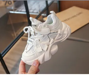 Detail view of girls' white mesh sneakers with chunky soles and fashion label