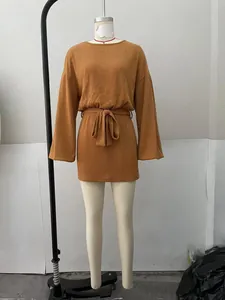 Dettaglio di un abito in maglia a costine giallo senape con maniche lunghe e cintura