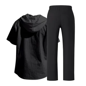Detail view showing black linen texture of short sleeve hooded shirt and trousers set
