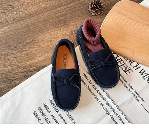 Detailed view of navy blue suede children's loafers with a decorative bow