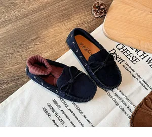 Classic navy blue children's moccasins with bow detail and soft suede texture