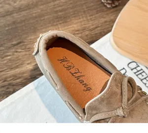 Close-up of beige suede children's loafers with soft brown cushioned leather insole.
