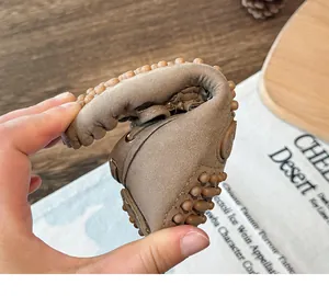 Macro view showing the flexibility and softness of brown suede children's loafers