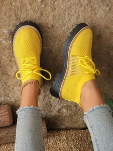 Close-up of vibrant yellow mesh lace-up platform sneakers on model for casual wear