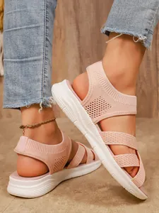 Primo piano di sandali piatti da donna in mesh rosa traspirante con suola bianca morbida