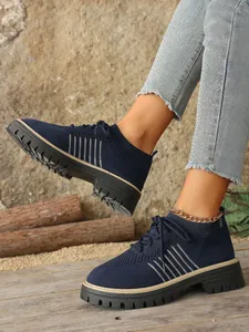 Detailed close-up view of navy blue mesh platform sneakers with thick sole and laces