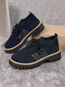 Detail of navy blue knit platform shoes with breathable mesh and lace-up design
