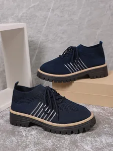 Detail view of navy blue knitted breathable shoes with durable thick platform lug soles.