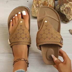 Detail of brown women's flip flops with laser-cut patterns and soft ergonomic soles