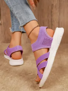 Dettaglio di sandali in mesh viola traspiranti con spesse suole bianche leggere