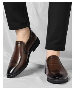 Gros plan de mocassins élégants en cuir dégradé marron pour hommes avec pantalon noir