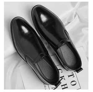 Vue de dessus de mocassins en cuir noir brillant pour hommes sur tissu blanc