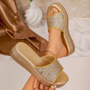 Detailed macro view of women's gold platform sandals with sparkling glitter straps.