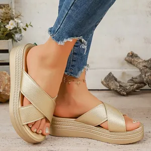 Detailed view of women's gold platform sandals with metallic criss-cross straps and thick sole