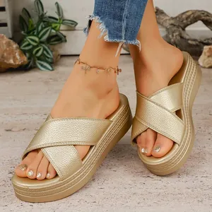Detail of stylish gold platform sandals with cross-strap design and textured finish