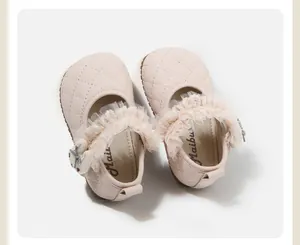 Detalle de zapatos Mary Jane rosas para bebé con volantes de encaje delicados.
