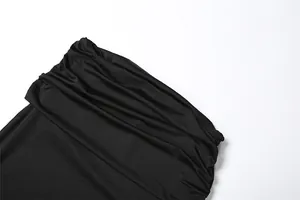 Detailed view of the elegant black ruched fabric texture from a slim fit skirt set.