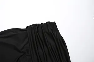 Detailed close-up showing the soft pleated texture of the black slim-fit skirt fabric.