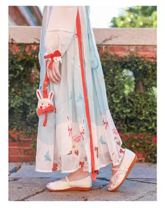 Detailed view of girls' white embroidered cloth shoes paired with traditional Hanfu dress.