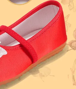 Detail of traditional red Hanfu embroidered shoes for girls with satin texture and strap