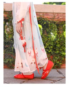 Close-up of traditional red embroidered girls' Hanfu shoes with white floral patterns