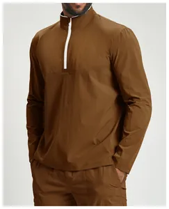 Close-up of brown athletic quarter-zip long sleeve top with white zipper detail