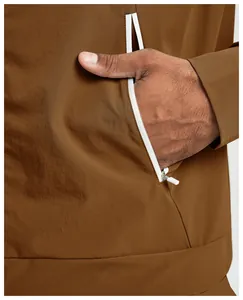 Detailansicht der weißen Reißverschlusstasche an brauner umweltfreundlicher Outdoor-Jacke