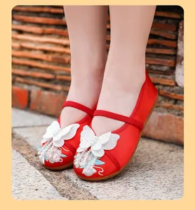Close-up view of red traditional Chinese embroidered shoes for girls with butterfly decor