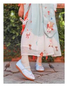 Close-up detail of light blue embroidered fabric shoes for kids paired with traditional Hanfu dress