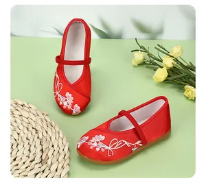 Traditional Chinese red embroidered shoes for girls with floral patterns and straps.