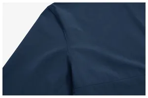Detailed close-up showing the precise shoulder seam and texture of navy blue athletic jacket