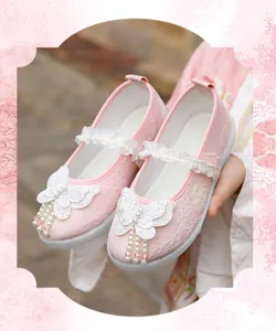 Close-up detail of pink Hanfu children's shoes with butterfly and pearl decor