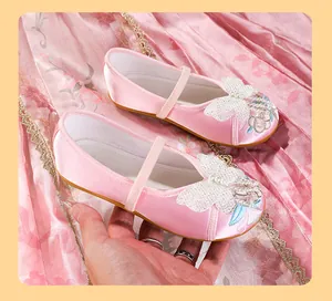 Detail shot of pink Hanfu embroidered shoes for girls featuring butterfly and pearl accents
