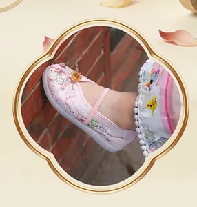 Detailed macro view of pink Hanfu girl shoes with delicate floral embroidery and pearls