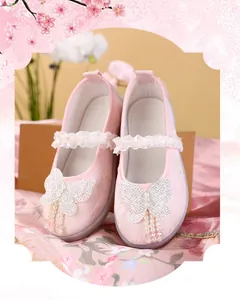 Close-up of pink Hanfu shoes for girls with pearl butterfly and lace trim detail